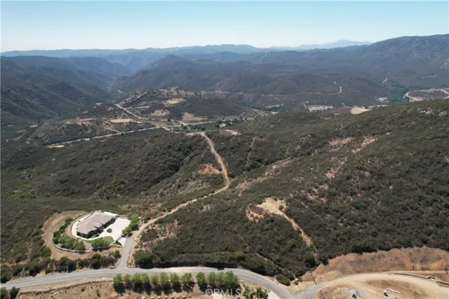 a view of a dry yard with mountains in the background