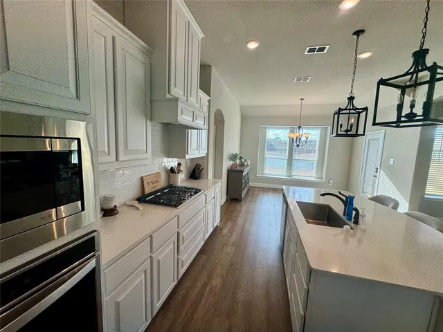 a kitchen with sink stove and cabinets