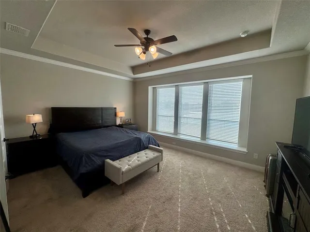 a bedroom with a bed and a flat tv screen on a dresser