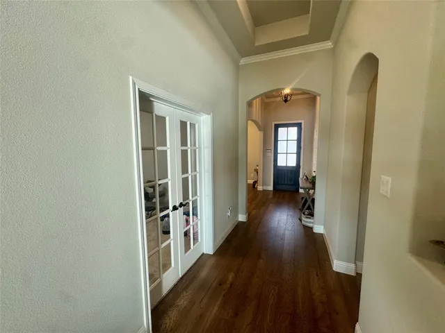 a view of a hallway with wooden floor and a living room