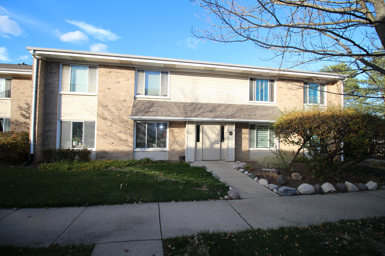 1700 Robin Lane, Unit 1D Hoffman Estates, IL 60169 - Photo 1 of 18 a front view of a house with a yard and potted plants