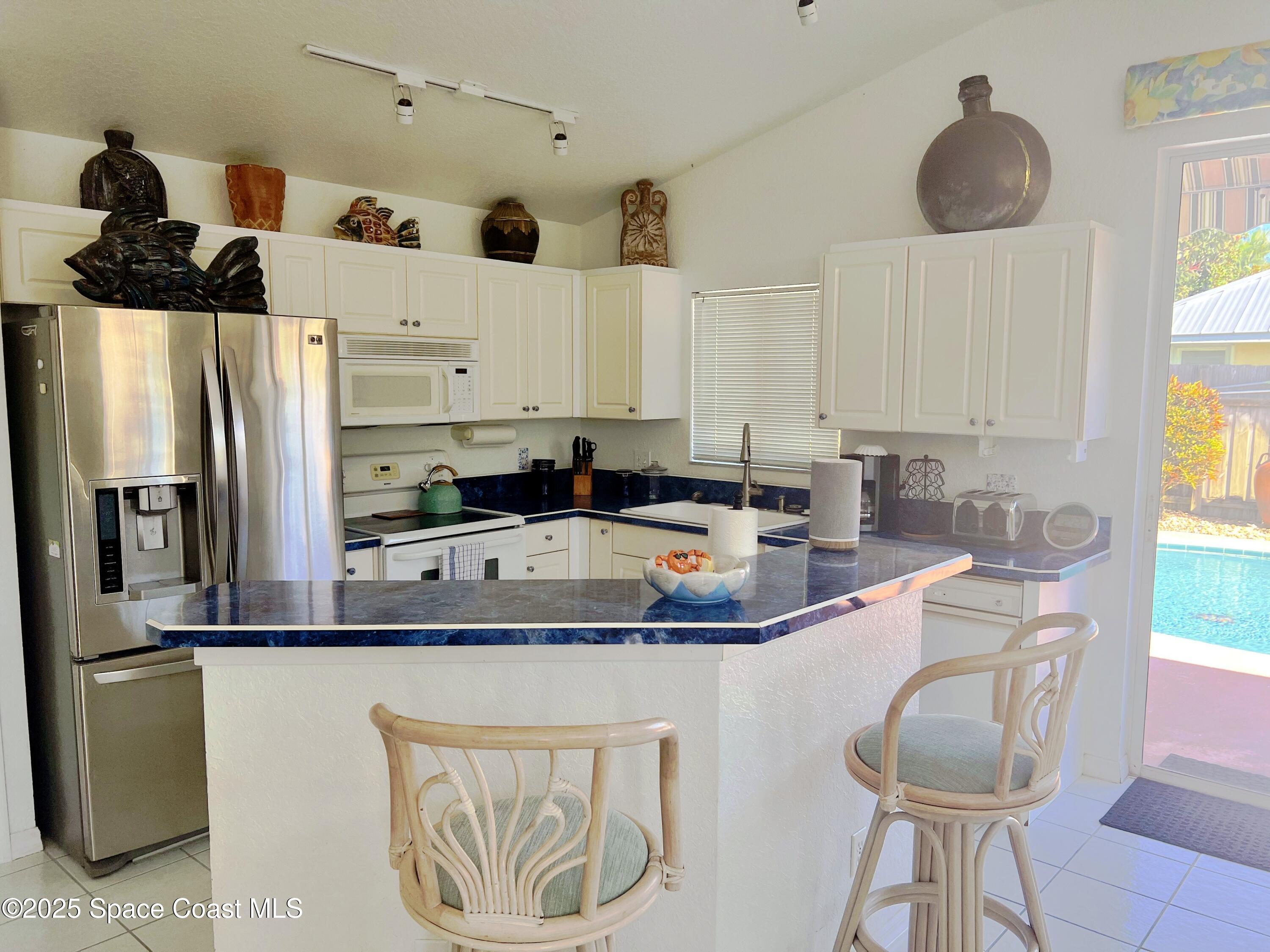 150 Sandy Shoes Drive Melbourne Beach, FL 32951 - Photo 17 of 31 a kitchen with stainless steel appliances granite countertop a sink a refrigerator and a stove