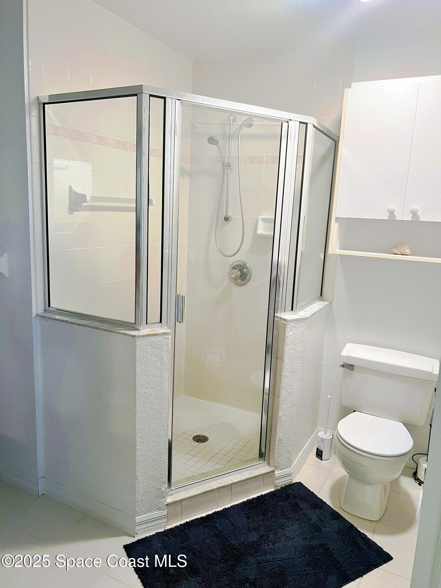 150 Sandy Shoes Drive Melbourne Beach, FL 32951 - Photo 19 of 31 a bathroom with a glass shower door