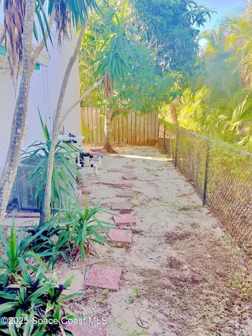 a view of a yard with plants and tree
