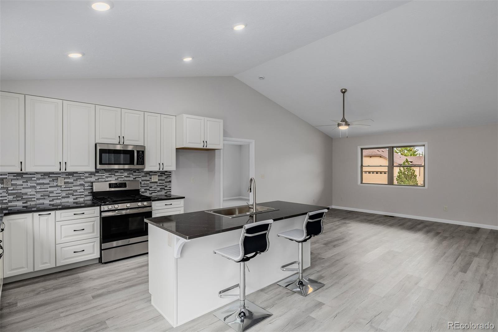 407 Double Tree Drive Greeley, CO 80634 - Photo 11 of 50 a kitchen with granite countertop a sink appliances and cabinets