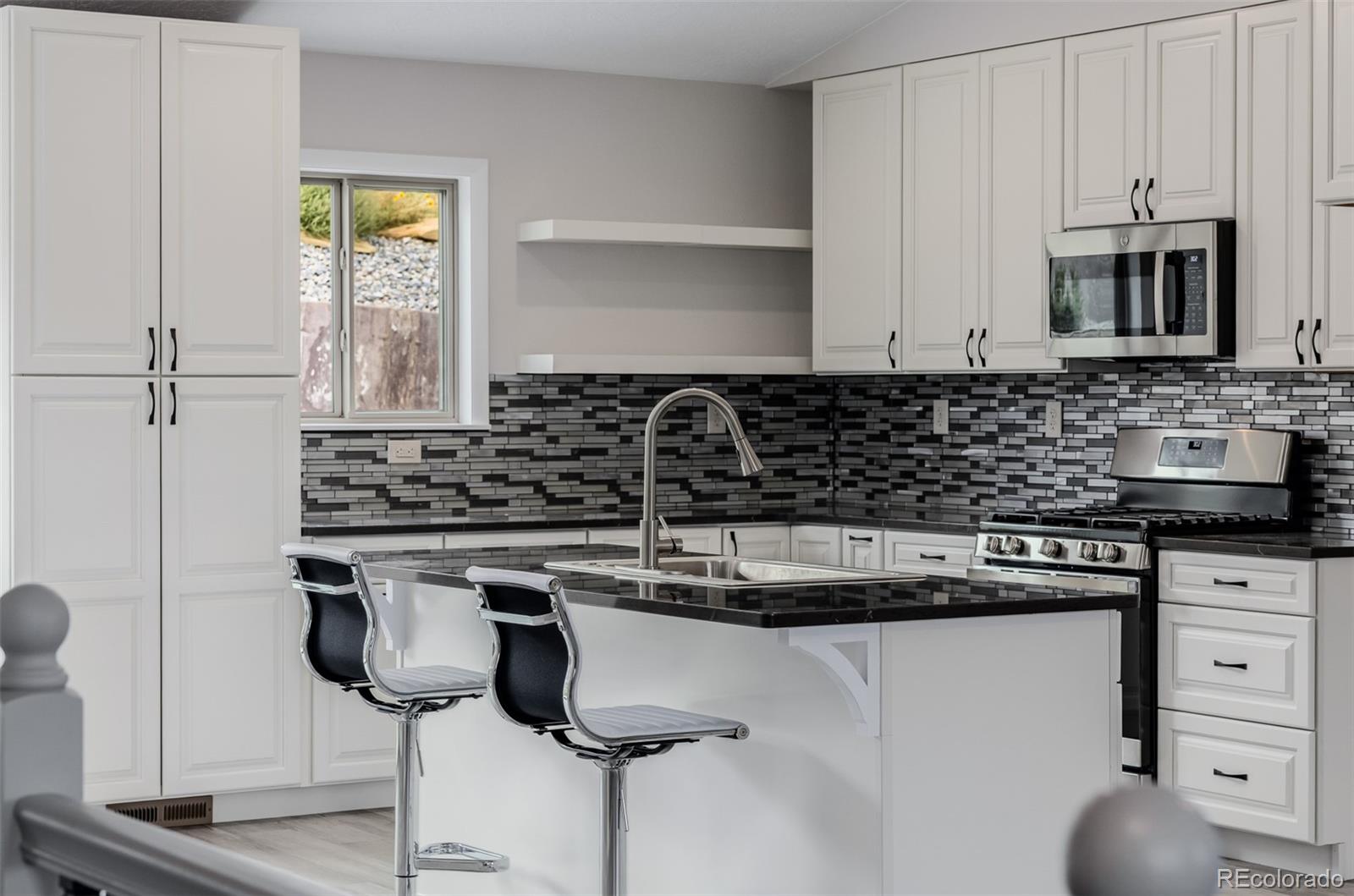 407 Double Tree Drive Greeley, CO 80634 - Photo 13 of 50 a kitchen with a sink a stove cabinets and appliances