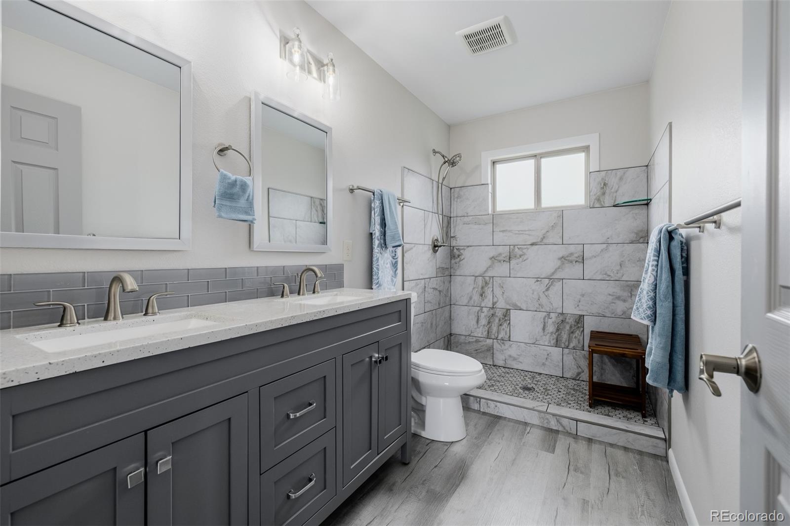 407 Double Tree Drive Greeley, CO 80634 - Photo 19 of 50 a spacious bathroom with a granite countertop toilet sink and mirror