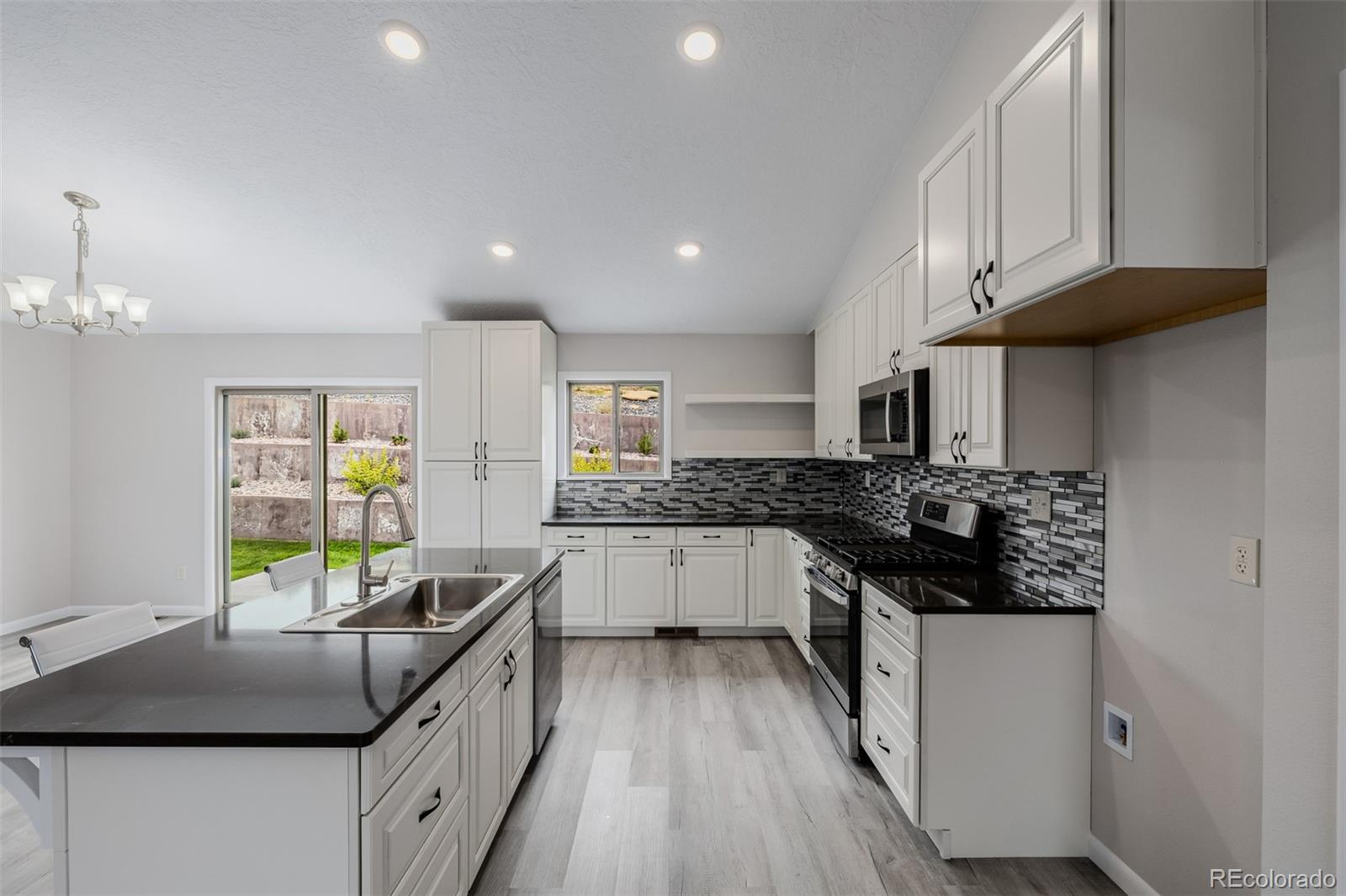 407 Double Tree Drive Greeley, CO 80634 - Photo 7 of 50 a kitchen with stainless steel appliances granite countertop a stove a sink and a refrigerator