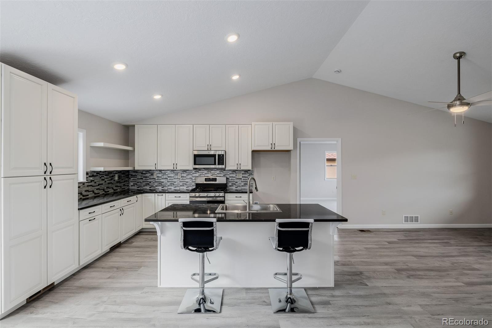 407 Double Tree Drive Greeley, CO 80634 - Photo 10 of 50 a kitchen with stainless steel appliances kitchen island granite countertop a stove and white cabinets