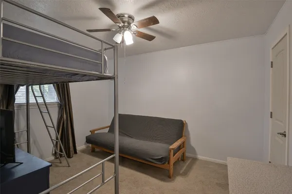 a living room with a couch and a ceiling fan