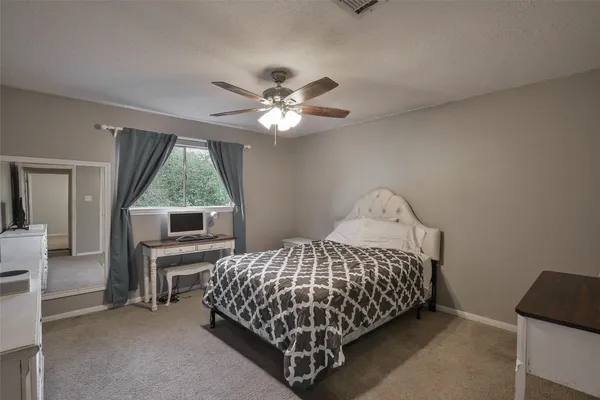 a bedroom with a bed and a ceiling fan