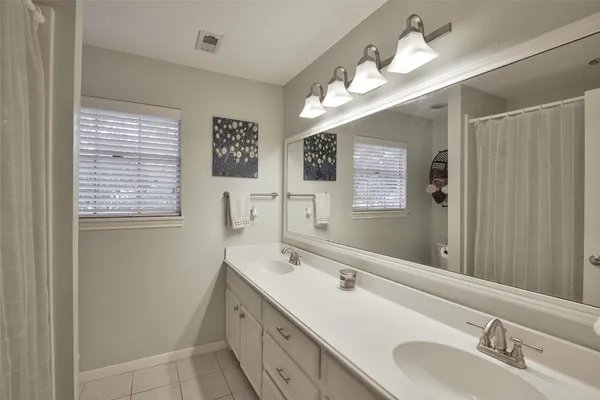 a bathroom with double vanity sink and a mirror