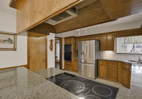 a kitchen with stainless steel appliances granite countertop a refrigerator and a sink