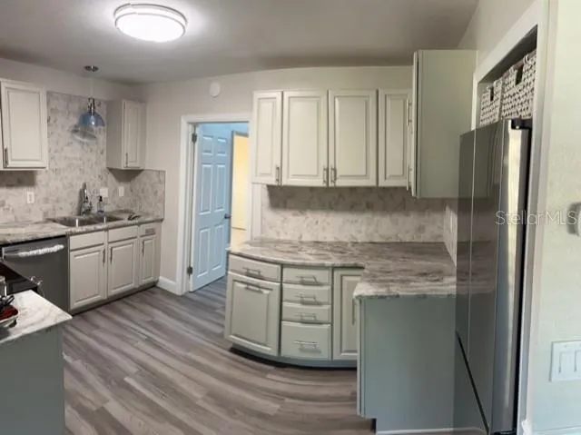 an empty room with wooden floor closet and windows