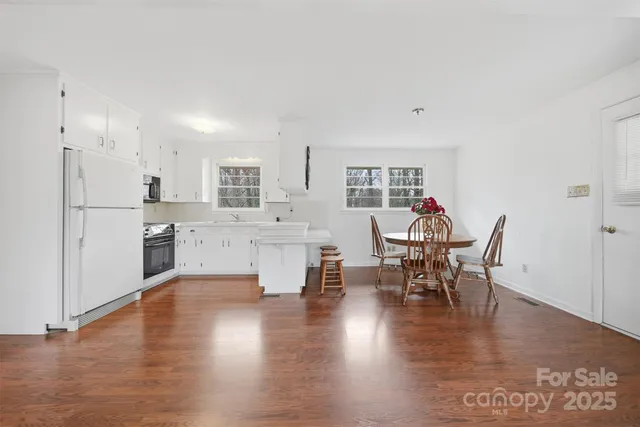 a large white kitchen with white cabinets and stainless steel appliances