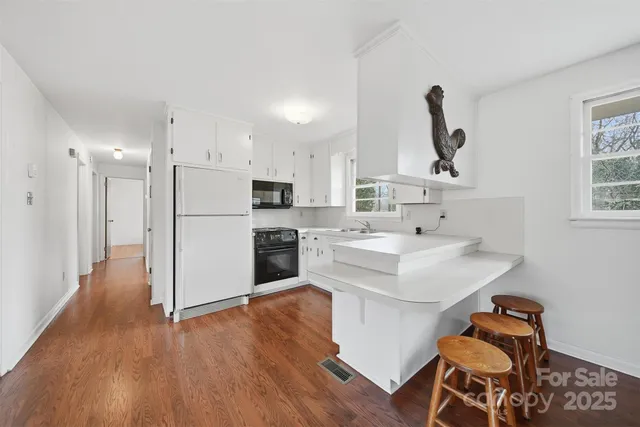 a kitchen with white cabinets and white appliances