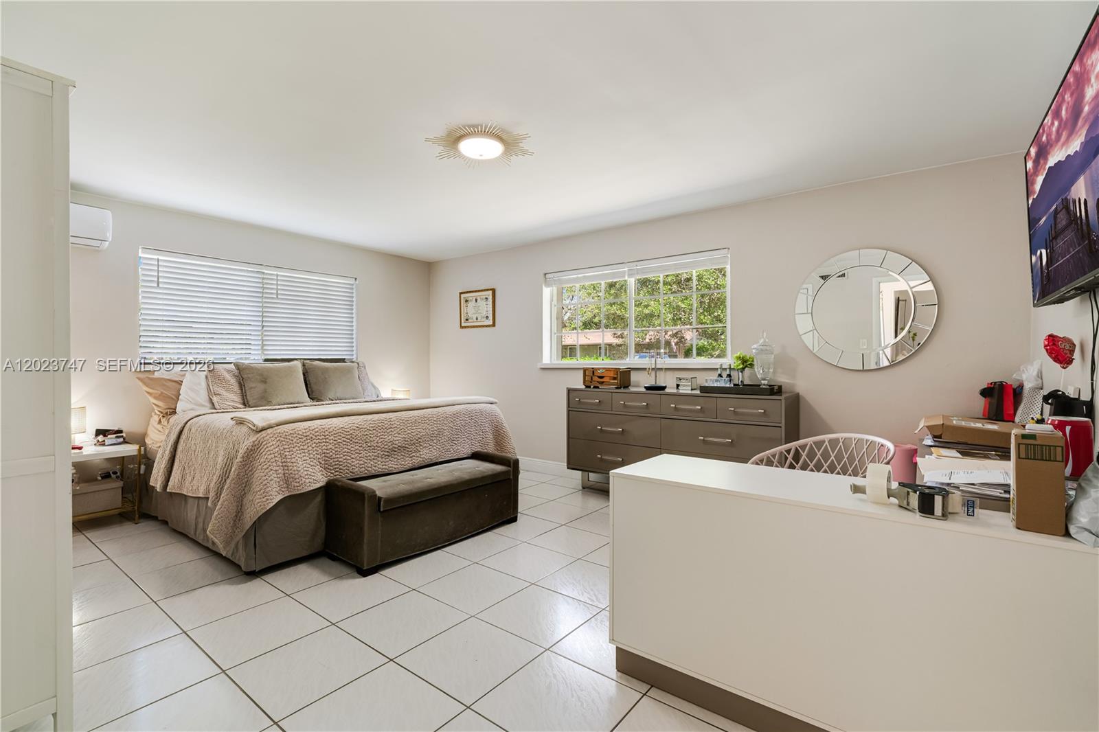 11515 Southwest 81st Road, Unit 11515 Pinecrest, FL 33156 - Photo 25 of 33 a bedroom with a bed mirror and window