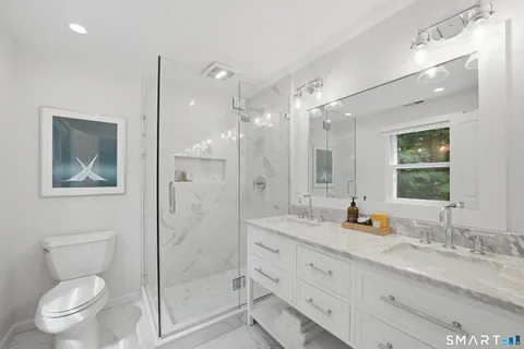 a bathroom with a granite countertop sink toilet and shower