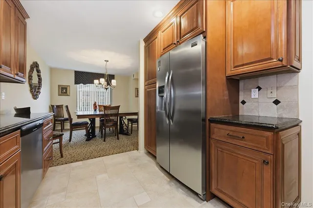a kitchen with stainless steel appliances granite countertop a refrigerator a stove and a sink
