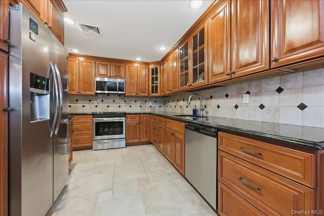 a kitchen with stainless steel appliances granite countertop a refrigerator and a sink