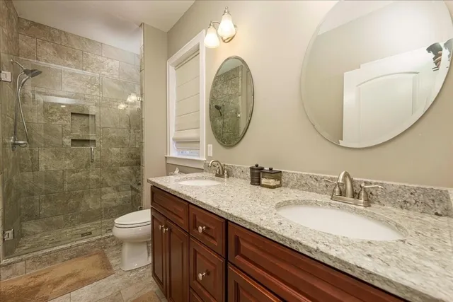 a bathroom with a granite countertop toilet a sink and a mirror