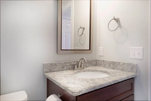 a bathroom with a granite countertop sink and a mirror