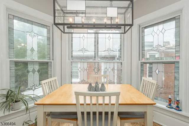 a kitchen with a sink dishwasher a stove and white cabinets with wooden floor