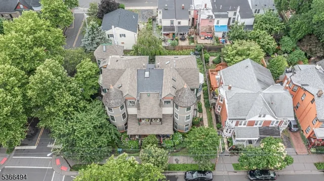 an aerial view of residential houses with outdoor space and trees