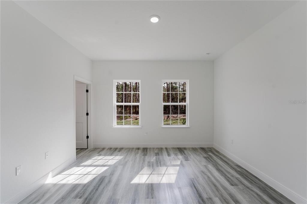 6732 Southwest 132nd Street Ocala, FL 34473 - Photo 25 of 36 an empty room with wooden floor and windows