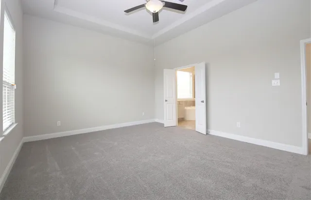 an empty room with fan and windows