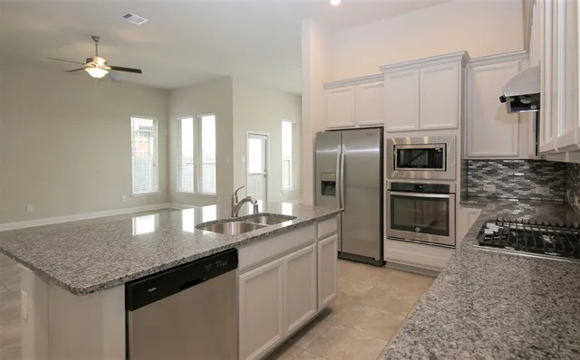 a kitchen with stainless steel appliances granite countertop a sink and refrigerator