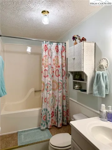 a bathroom with a toilet and a shower curtain
