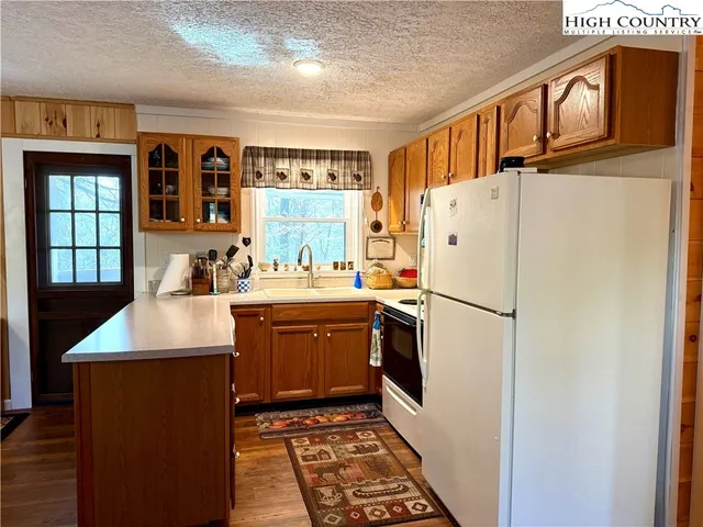 a kitchen with stainless steel appliances granite countertop a refrigerator a stove a sink and a dining table with wooden floor