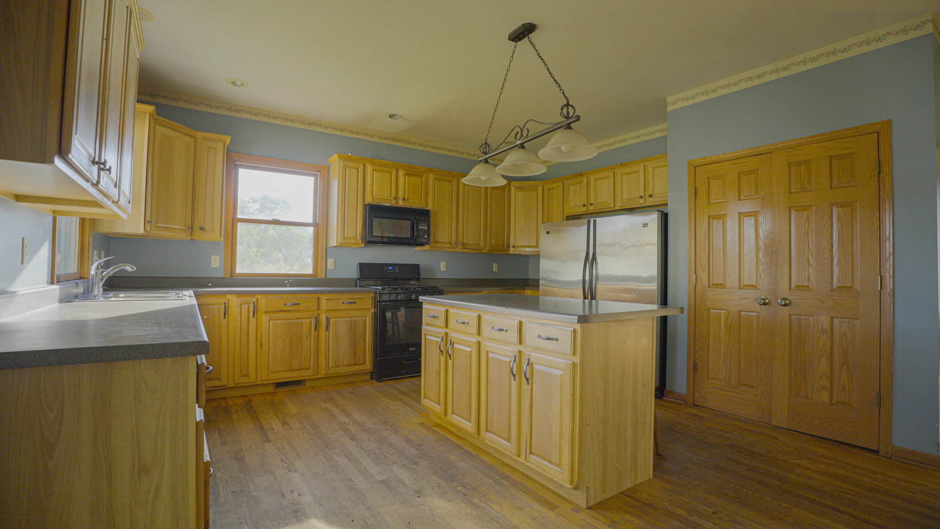 9282 East Hemstock Road Rochelle, IL 61068 - Photo 6 of 68 a kitchen with a refrigerator a sink cabinets and wooden floor