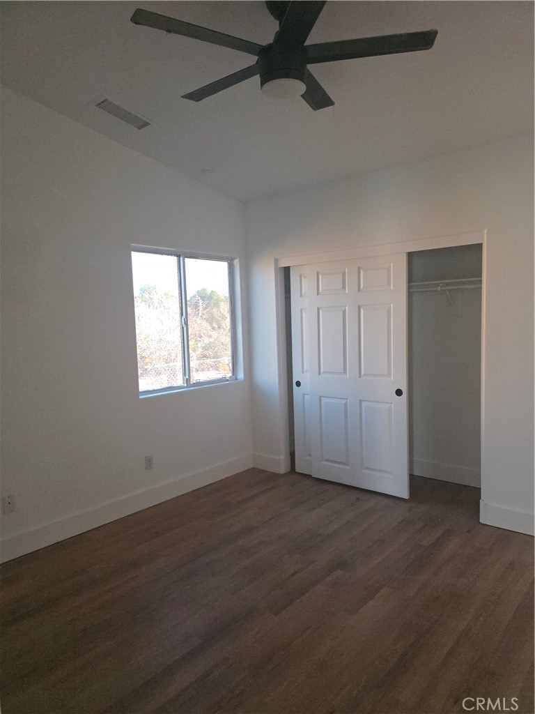 57336 Crestview Drive Yucca Valley, CA 92284 - Photo 8 of 19 a view of an empty room with wooden floor and a window