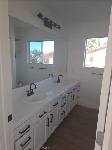 an empty room with wooden floor and fan