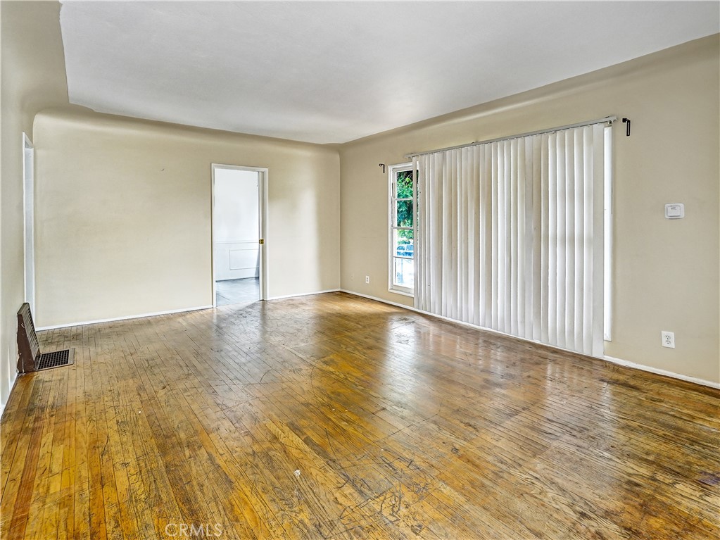 7928 Milton Avenue Whittier, CA 90602 - Photo 19 of 27 an empty room with wooden floor and windows