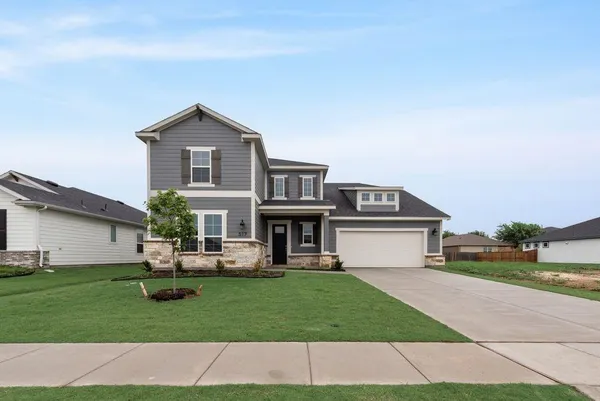 a front view of a house with a garden and plants