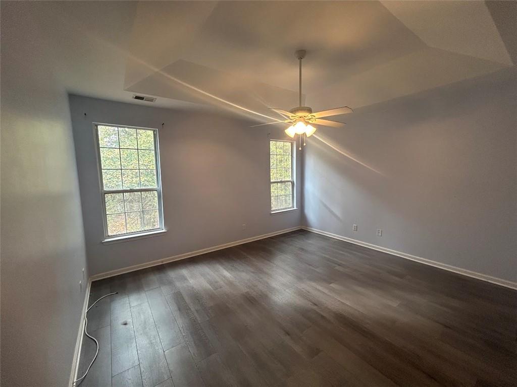 3220 Waterplace Cove Villa Rica, GA 30180 - Photo 12 of 36 an empty room with wooden floor chandelier fan and windows