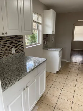 a kitchen with stainless steel appliances granite countertop a sink and a white cabinets