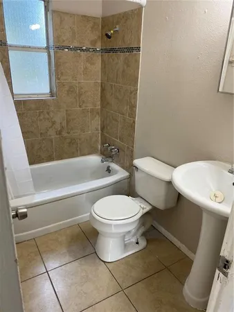 a white toilet sitting next to a bath tub and a shower