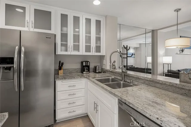 a kitchen with granite countertop a refrigerator and a sink