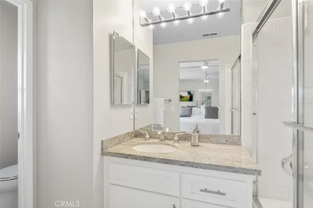a bathroom with a granite countertop sink and a mirror