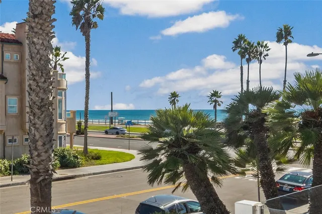 a view of a swimming pool with a lawn chairs and palm trees
