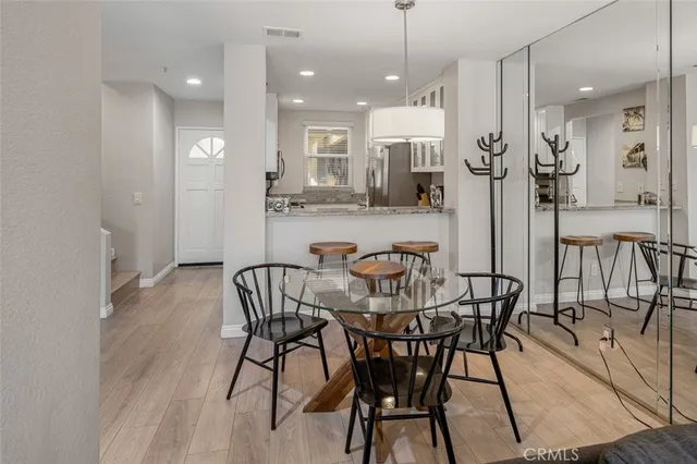 a view of a dining room and livingroom with furniture wooden floor a rug a chandelier