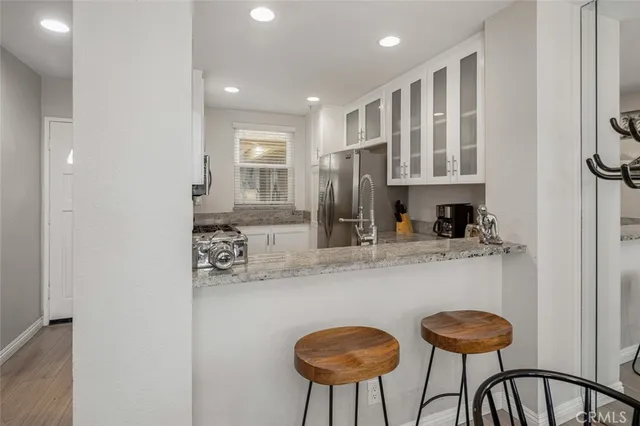 a kitchen with stainless steel appliances granite countertop a sink and a refrigerator