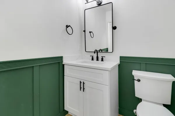 a bathroom with a toilet sink and mirror