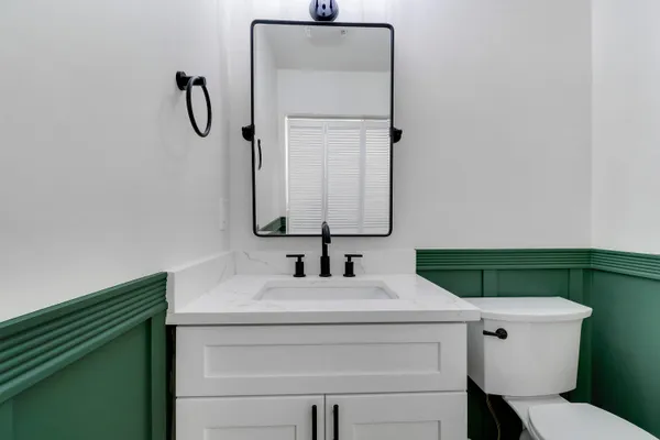 a bathroom with a sink vanity and toilet