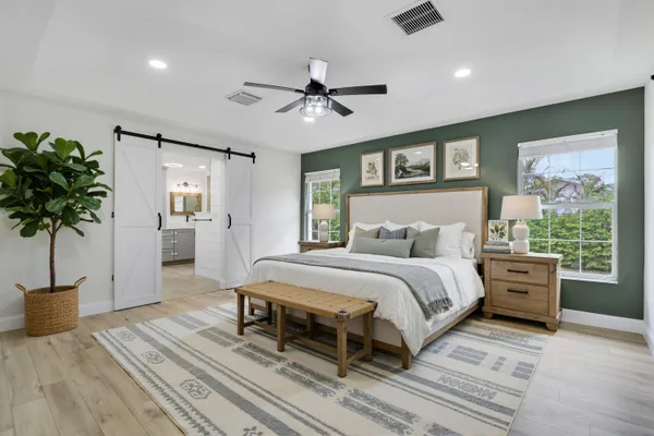a spacious bedroom with a large bed and a potted plant