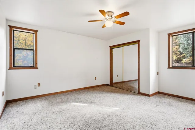 an empty room with fan and a chandelier fan